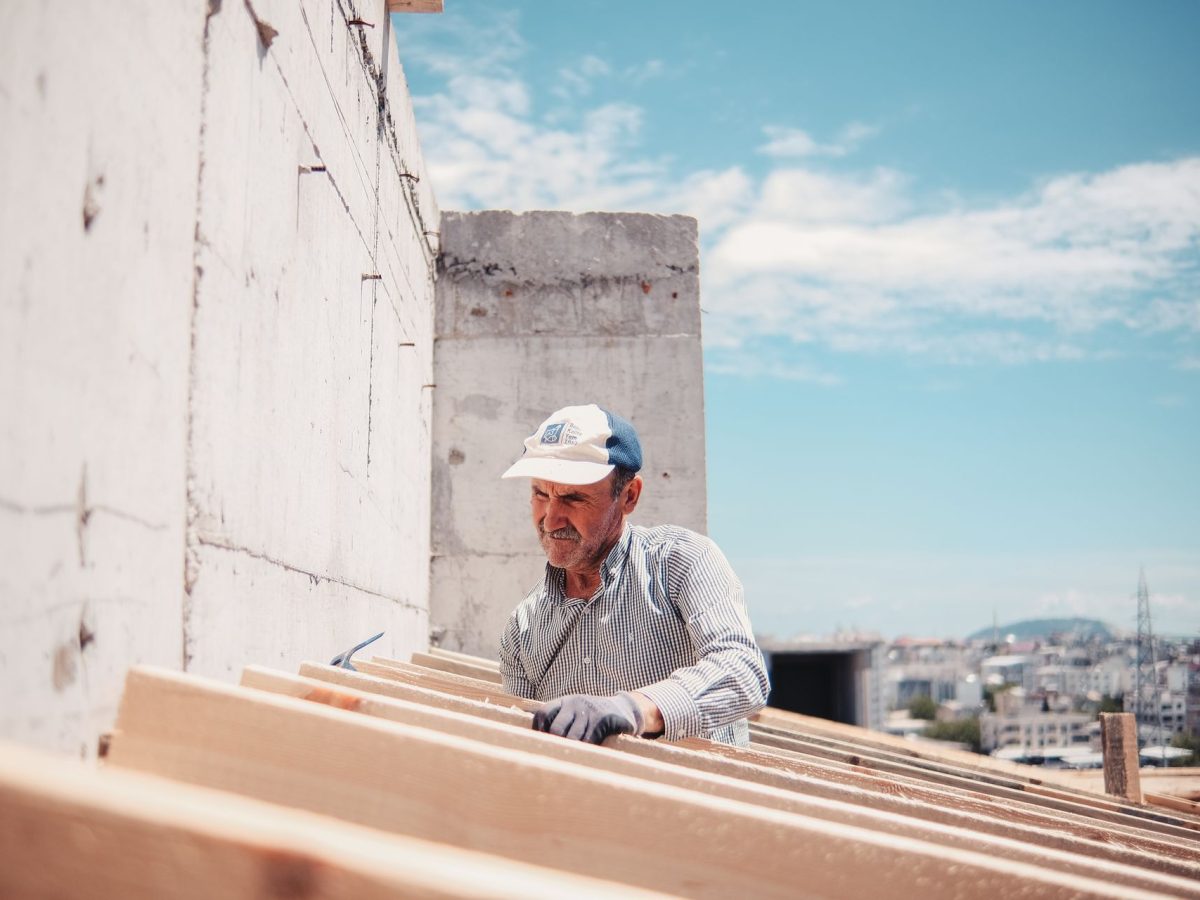 Handwerker arbeitet an Dachbalken bei einem Dachausbau