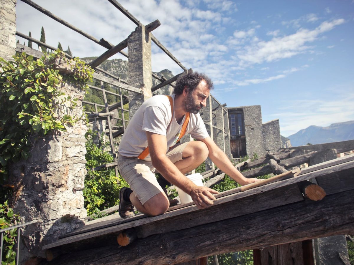 Handwerker arbeitet konzentriert auf einem Holzdachstuhl